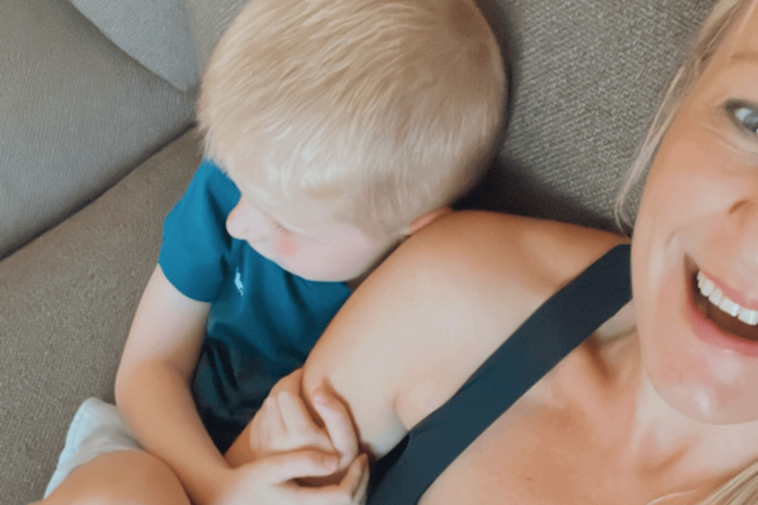 Woman cuddling with her son on the sofa during an evening coaching call, blending work and family life