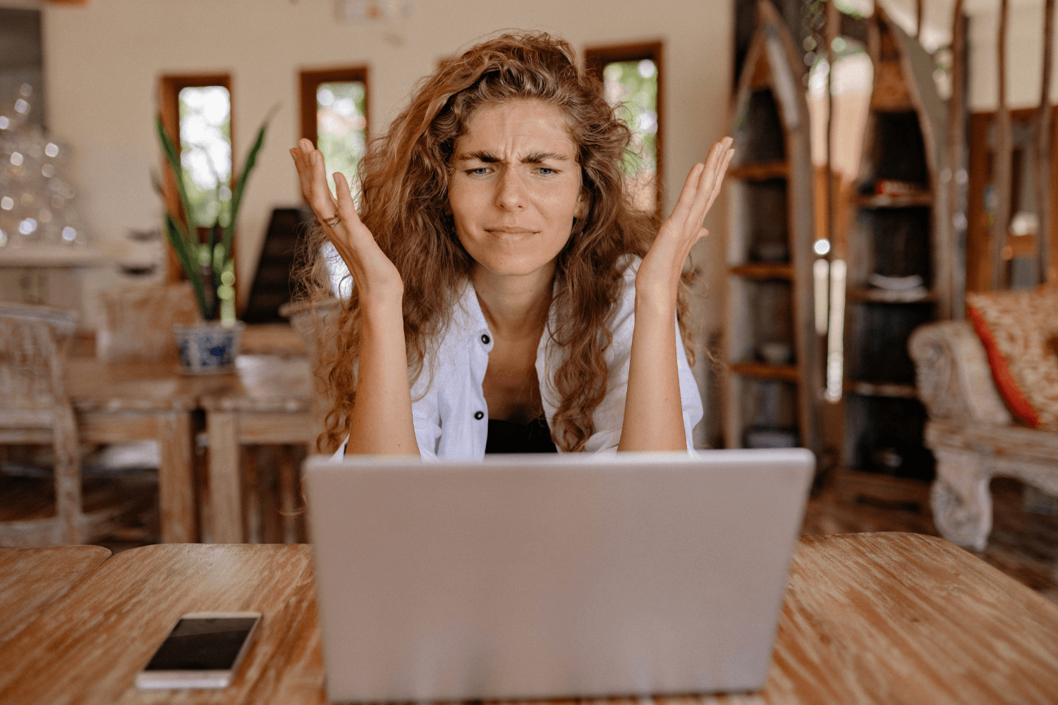 Woman looking stressed while working on laptop, representing content planning overwhelm