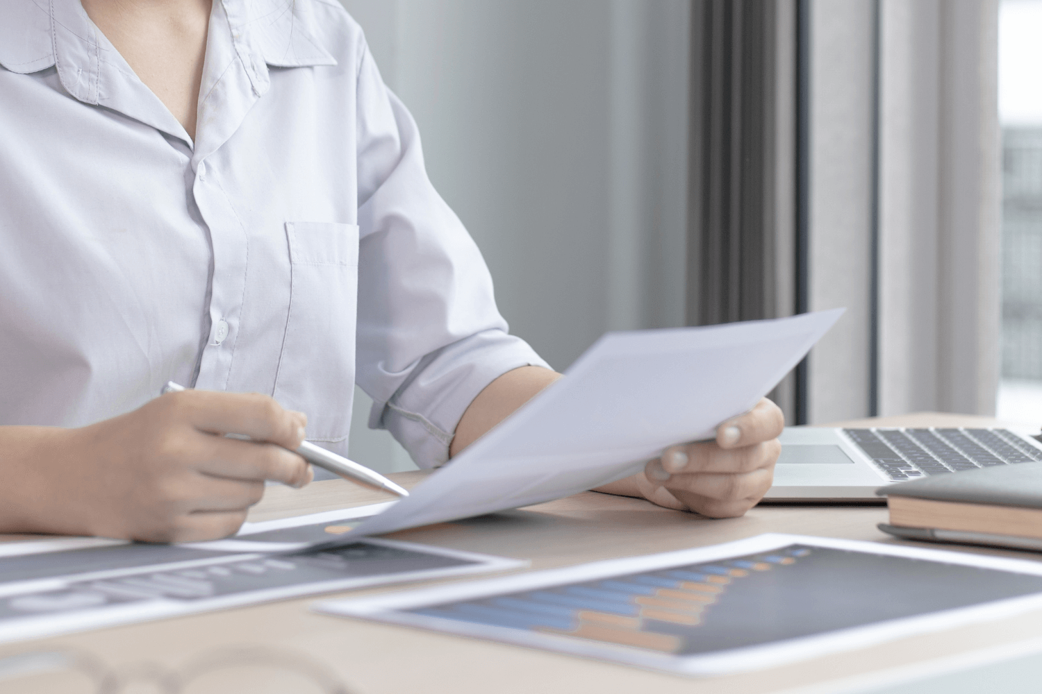 Small business owner running a DIY marketing audit with laptop and checklist