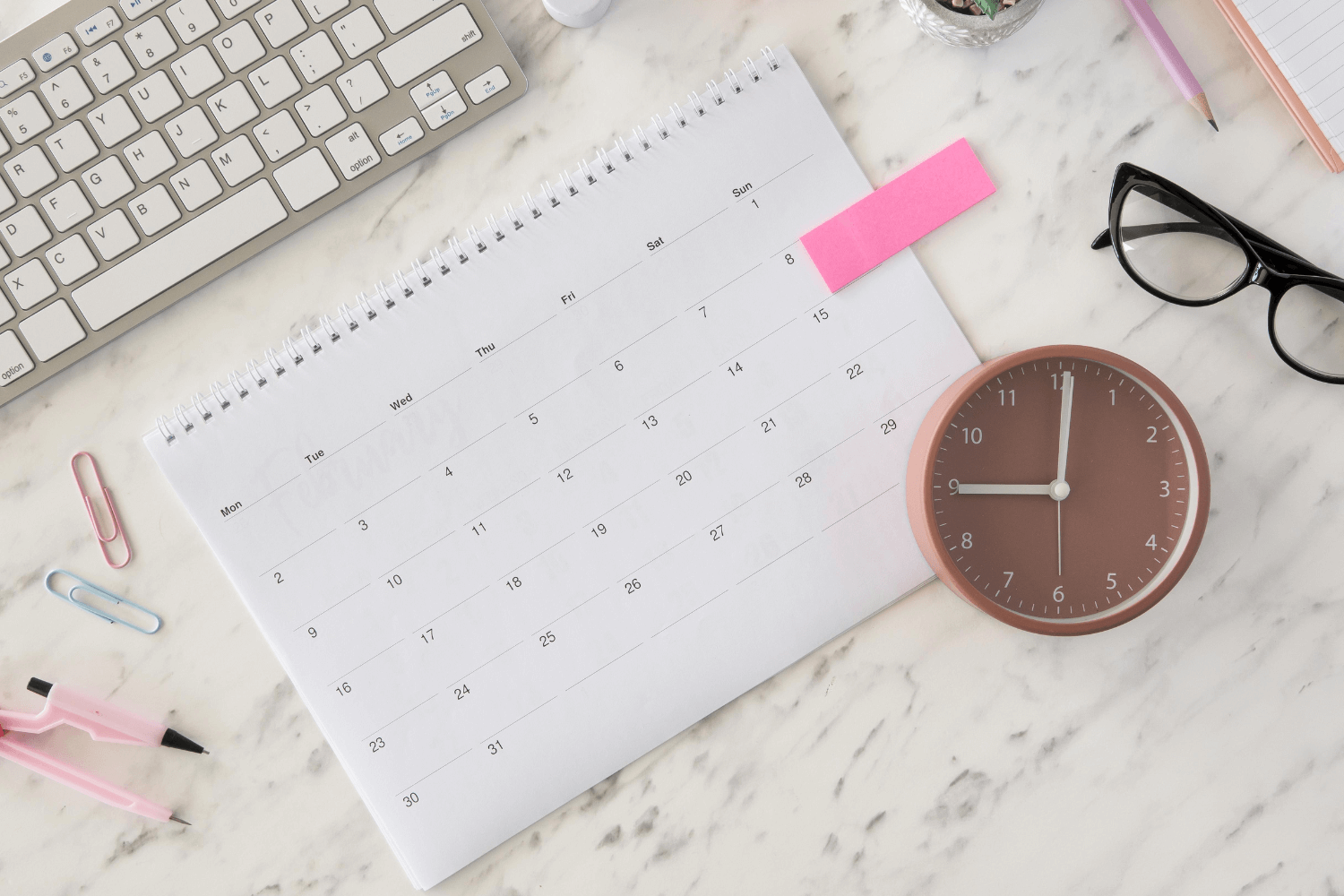 Flat lay image of a social media marketing strategy setup with phone, content calendar, and coffee mug, representing strategic planning for digital content.